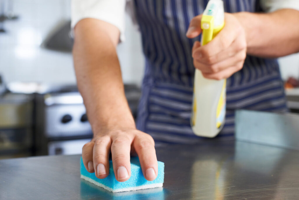 A person holding a sponge and a spray.